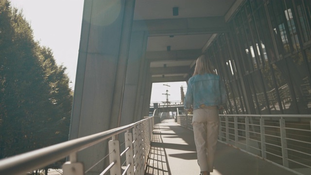 女子在人行桥上骑电动踏板车视频素材