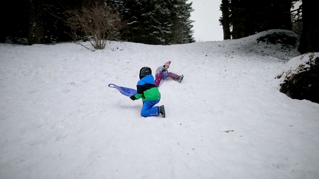 不幸。孩子们在雪地上骑得太快，在滑雪橇时摔倒视频下载