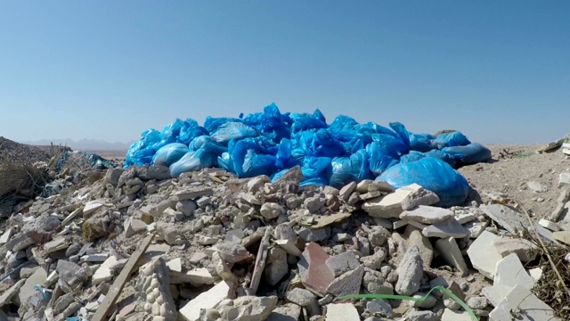 一个蓝色塑料袋里的垃圾躺在海边视频素材