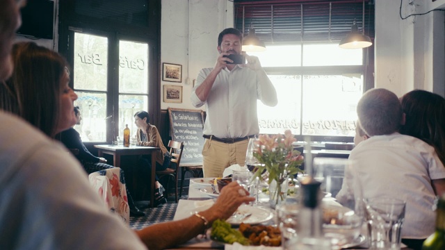 一个多代拉丁美洲家庭在餐厅用餐的合影视频素材