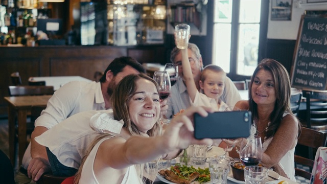 一个多代拉美家庭在餐厅聚餐时的集体自拍视频下载