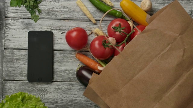 蔬菜在智能手机和杂货附近旋转。素食者的概念视频素材
