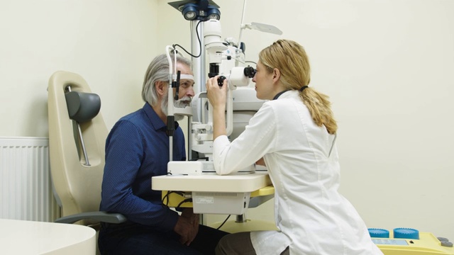 女医生在眼科诊所检查一位老年病人视频下载