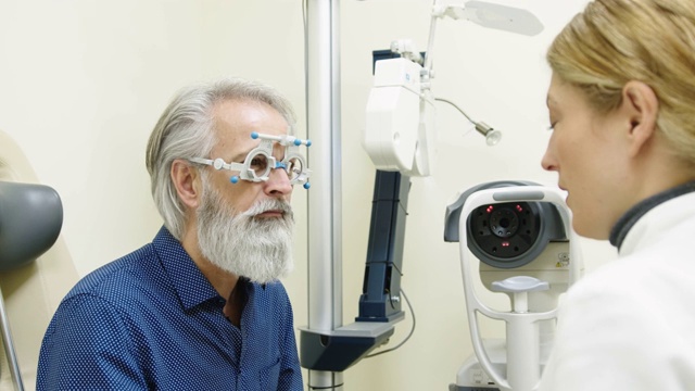 女医生正在检查一位老年男子的视力视频素材