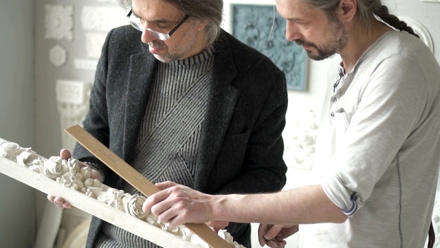 两个成熟的男性雕刻家测量花之间的距离视频下载