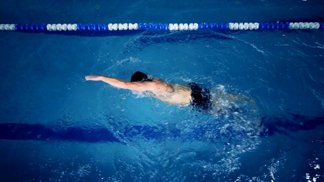 一个男性游泳者在游泳池里戴着假肢的俯视图视频下载
