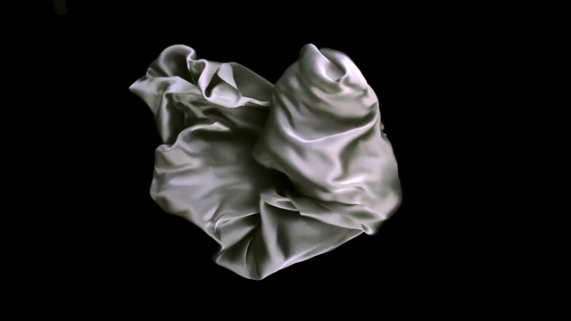 银色褶皱的丝质织物在画面中心以超慢的动作流动，黑色的背景。视频素材