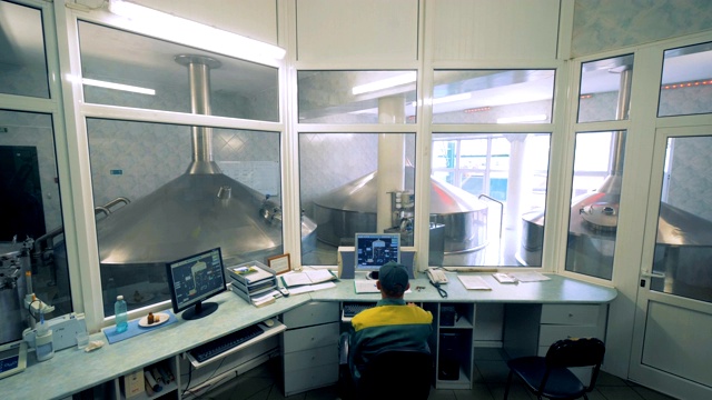 在一个蒸馏厂的监督单位，有一个人坐在里面观察过程视频下载