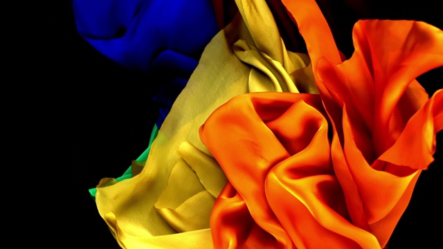 黄色,蓝色,红色。橙色和绿色的丝质织物纠结和流动在超级慢的动作和近距离的黑色背景。视频下载