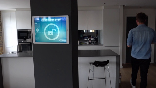 男子锁他的房子与智能家庭系统使用平板电脑的技术概念视频素材