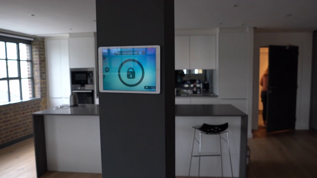 女人锁她的房子与智能家庭系统使用平板电脑的技术概念视频素材