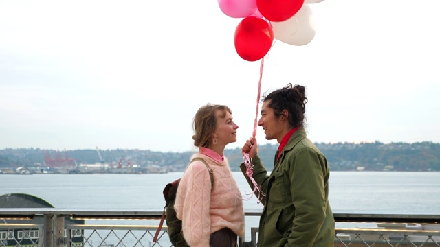 情侣们在情人节这天手捧心形气球亲吻视频素材