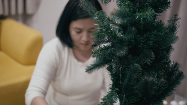 亚洲男孩和妈妈装饰圣诞树视频素材