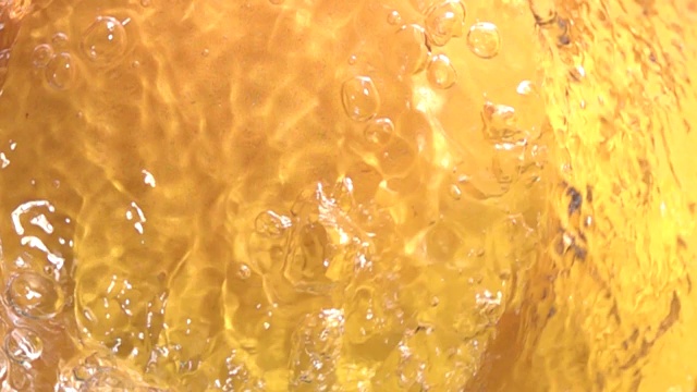 黄色背景上的水流漩涡以慢动作呈现视频素材
