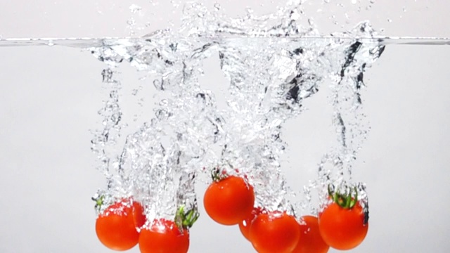 超级慢镜头:在白色背景下，番茄掉进淡水中视频素材