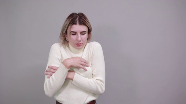 严格的年轻女子在淡色衬衫，手交叉的寒冷季节概念。视频素材