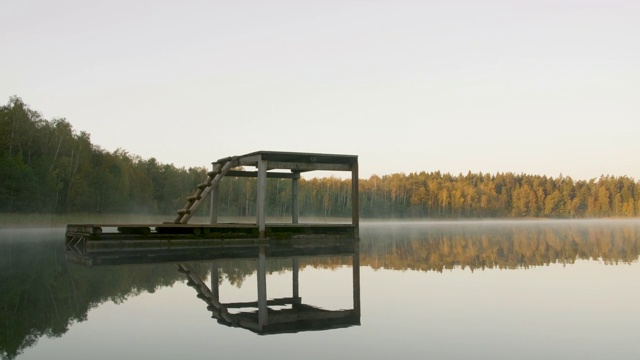 跳水木塔在湖上的晨雾旁边的秋天的森林视频素材