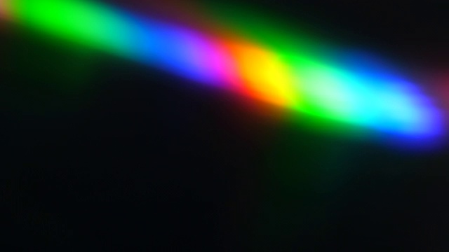 黑色背景上的彩色光束和光线。抽象背景彩虹CD。美丽的彩色镜头光彩虹光束电影和电影院在晚上。将光线分成光谱颜色的棱镜。视频下载