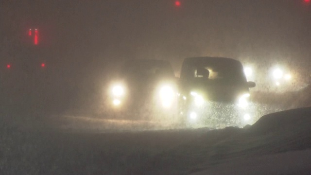 日本北海道，暴风雪中夜晚行驶的汽车视频素材