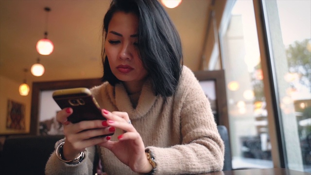 紧张的亚洲女人用手机发短信视频下载