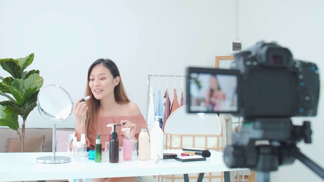 美丽的亚洲女人博客展示如何化妆和使用化妆品。在摄像机前录制在家的视频直播。商业在线影响者对社交媒体的概念。视频素材
