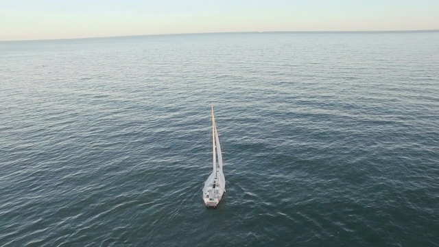 一艘帆船在海岸线附近海上航行的轨道航拍照片。视频素材