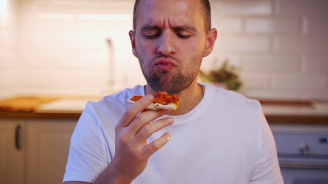 一个年轻漂亮的男人吃着一片披萨的肖像视频素材