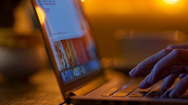 女性用手指在笔记本电脑上打字。晚上的暗室。滑动,UHD视频素材