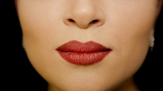 一个唇上涂着红色唇膏的女孩的飞吻。全高清视频视频素材