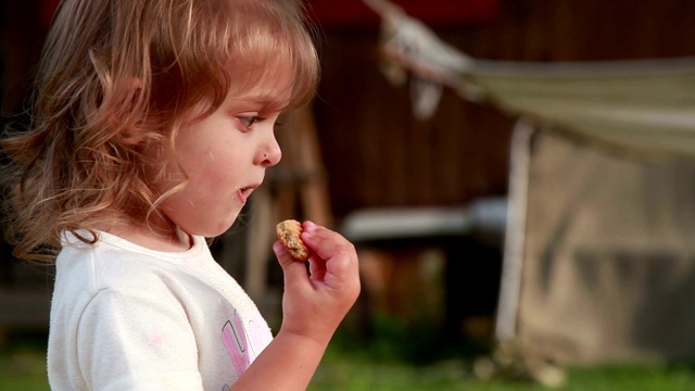 一个沉思的孩子正在吃饼干视频素材