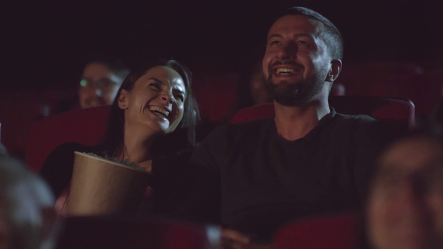 在电影院大笑的幸福夫妇视频素材