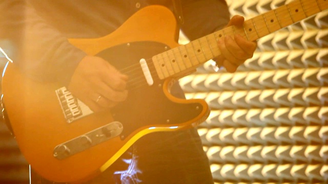 男子在聚光灯下的舞台上弹奏电吉他视频下载