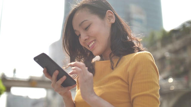 亚洲女性在城市中使用智能手机视频素材