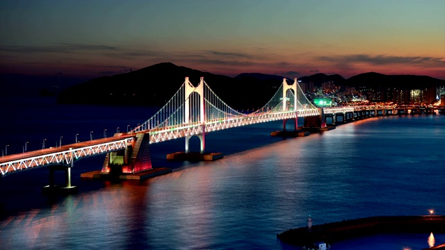 日落和夜景的光andaegyo大桥和海洋/ Suyeong-gu，釜山，韩国视频素材