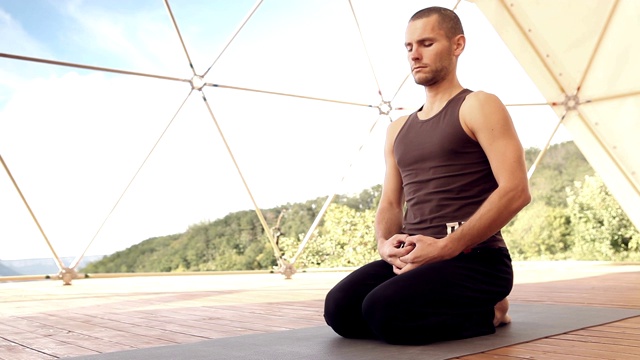 专业的瑜伽教练-教练在高山体育馆以禅宗坐姿或日本坐姿做呼吸集中练习。视频素材