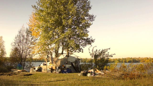在河边的秋天，一个无家可归的房子。视频素材