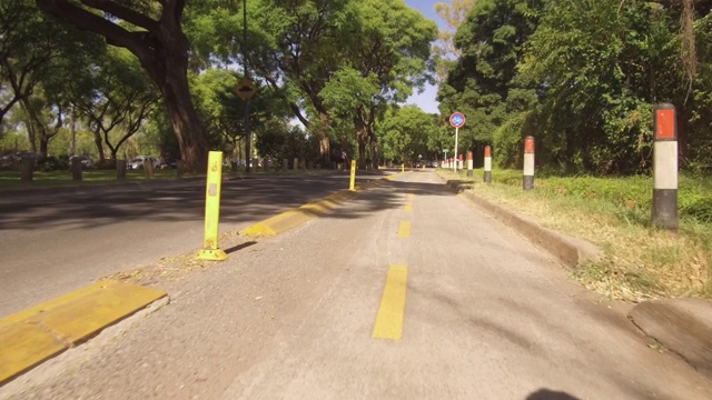 骑自行车的人通过自行车道，通勤。盘子，晴天，树。视频下载