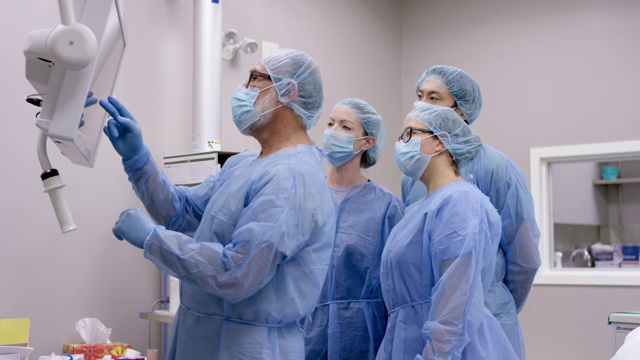 男性外科医生在手术前与手术团队一起评估病人的医疗状况视频下载