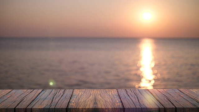 美丽的日落在近海，海面与小波浪与木制前景。视频下载