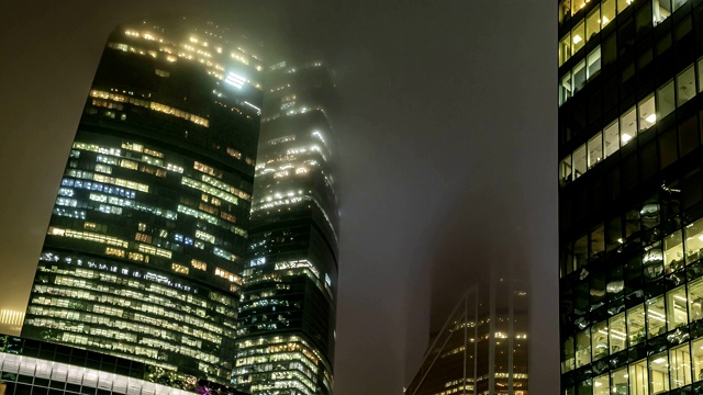 摩天大楼和商务中心的办公窗口在一个雾蒙蒙的夜晚，时光流逝，视频素材