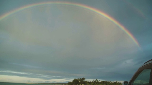 彩虹映衬多云的天空。视频下载