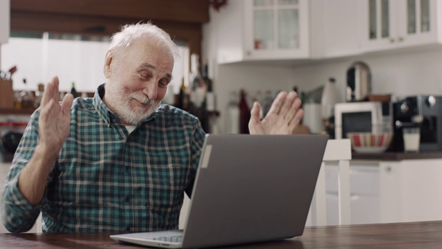 微笑的老人使用笔记本电脑视频素材