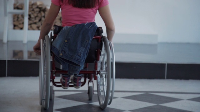 坐在轮椅上的年轻女子离开了她的房间视频素材