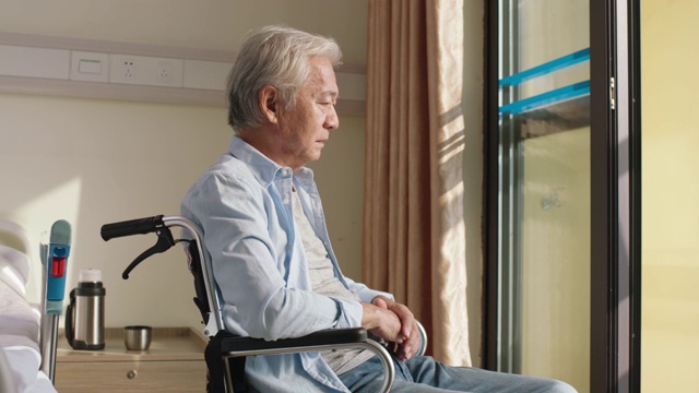 年长的亚洲人独自坐在轮椅上视频素材