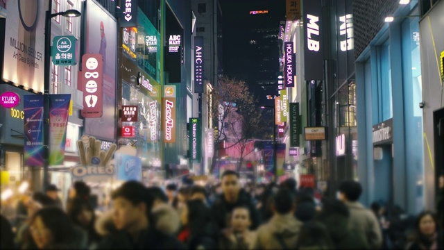 人群走在繁忙的购物街在韩国城市生活的夜晚视频下载