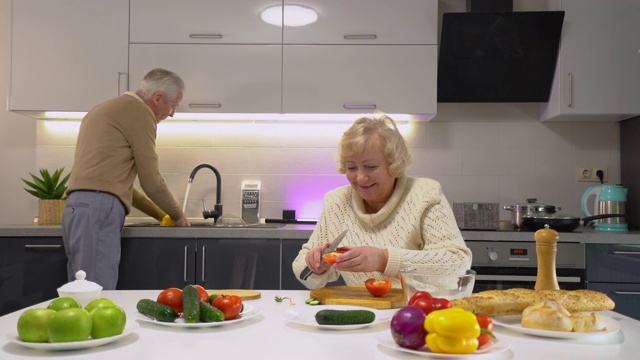 俏皮的老夫妻在厨房做饭，丈夫和妻子开玩笑，婚姻幸福视频下载