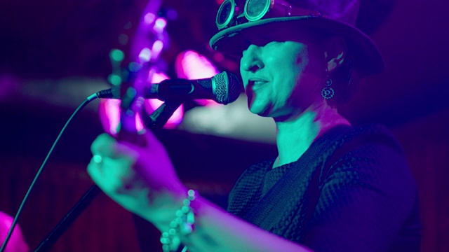 这位45岁的成熟女性、音乐家兼歌手的视频形象，穿着蒸汽朋克服装、戴着帽子、戴着眼镜视频素材
