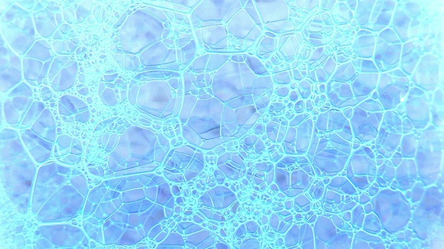 彩色的肥皂泡沫与弹出的泡沫背景。摘要生物结构，大分子格局。蓝色墨水填充了液体中形成的大量白色小气泡。天然和不寻常的墙纸。大量的泡沫，蓬松，迷人的肥皂泡沫。视频下载