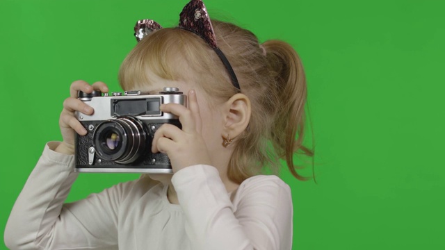 戴着猫头巾的女孩用老式复古相机拍照。色度键视频下载