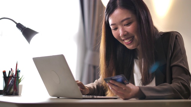 亚洲女人在笔记本网上购物视频素材